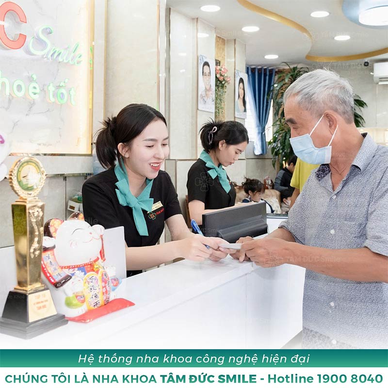 nhân viên chăm sóc khách hàng tận tâm hướng dẫn thủ tục tại nha khoa Tâm Đức Smile