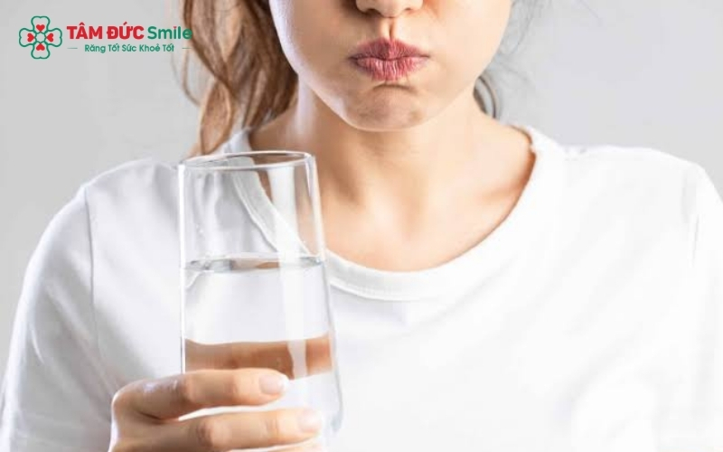 Súc miệng bằng nước muối ấm giúp làm sạch vi khuẩn và làm dịu vùng nướu quanh răng bị đau.