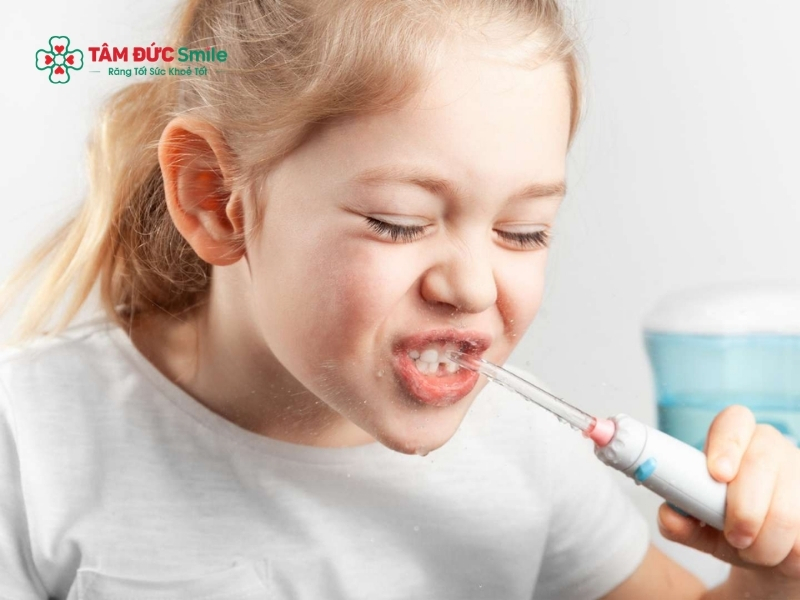 Vệ sinh kỹ vùng nướu đang sưng bằng bàn chải lông mềm và súc miệng nước muối giúp ngăn ngừa vi khuẩn tích tụ gây viêm lợi trùm cho trẻ.